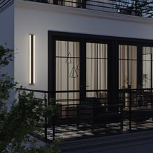 Load image into Gallery viewer, Rhea Outdoor LED Wall Light in Outside Area.
