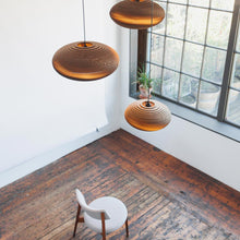Load image into Gallery viewer, Disc Pendant Light in living room.

