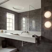 Load image into Gallery viewer, AJ Eklipta Wall Light in bathroom.

