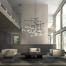 Load image into Gallery viewer, Suspenders® 4-Tier Tri-Bar LED Pendant Light in living room.
